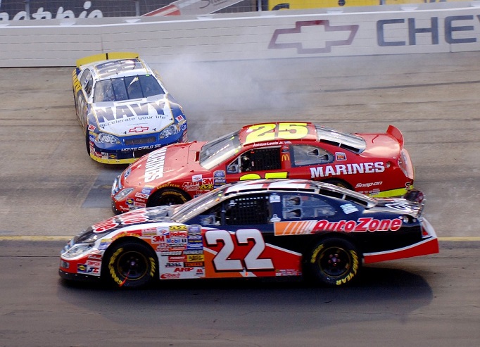 A NASCAR car loses control and skidding sideways as other cars pass by